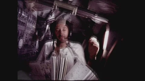 1960s: Astronauts play with floating objects in space shuttle cabin.  Men eat Video stock 109218974