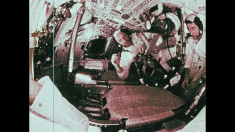 1960s: Astronauts in spacecraft pass objects around. Objects float about inside Video stock 104881977