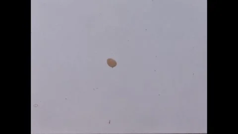 1960s: Balloon with string and item attached float away in sky. Stock Footage 277654563