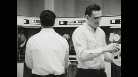 1960s Baltimore: people working at computers that are printing out sheets of Stock Footage 143439489