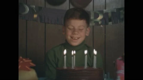 1960s: boy with chipped tooth. Boy by birthday cake and candles. Boy smiles at Stock Footage 194188027