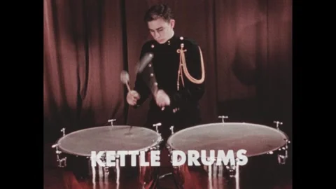 1960s: Boy plays a pair of timpani. Boy operates foot pedal to change pitch of Stock Footage 250703951