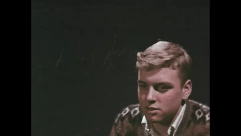 1960s: Boy thinks in transparent overlay as football game plays. Prompt to pay Stock Footage 251001607