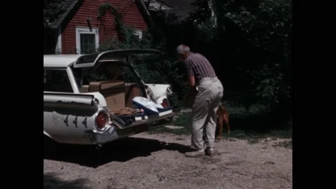 1960s: children help dad load up car for holiday. Maths equation on paper. Stock Footage 219965630