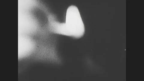 1960s: Close up, hand lights pipe, tilt down hookah. People smoke hookah. Vidéo 76815207