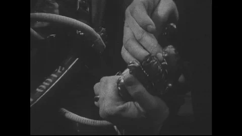 1960s: Close up of model's hand, zoom out to man modeling space suit. Stock Footage