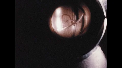 1960s: Close up, rocket engine firing. Man in lab. Model spacecraft parts push Stock Footage 106412609