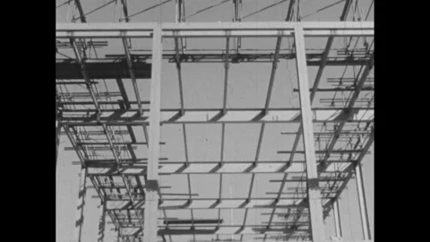 1960s: Construction site. Right, ninety degree angle line over construction Stock Footage 252861273