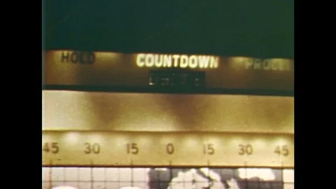 1960s: Countdown monitor lit up in control room. Friendship 7 rocket moves into Stock Footage