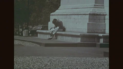 1960s: A couple studies a map while sitting at the base of the Arch de Triumph, Stock Footage 156939647