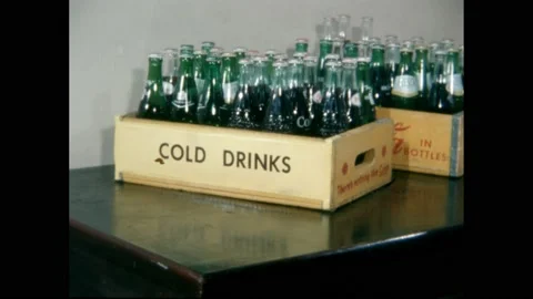 1960s: Crates of soda on table, hand sets down bottle, zoom in. Stock Footage 228835005