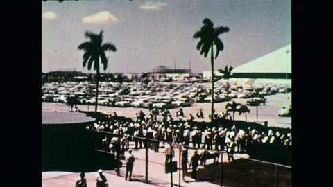 1960s: a crowd of people in a queue and parked cars / close up of crowd / people Stock Footage 74696968