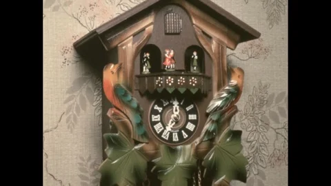1960s: A cuckoo wall clock with pairs of spinning figures. 스톡 동영상 244536110