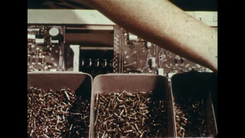 1960s: Dissolve to hands making processors / Hands clip wires on switchboard / Stock Footage