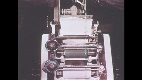 1960s: Dough moves through rollers. Flat sheets of dough go through roller. Stock Footage 78492875