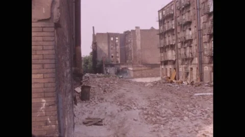 1960s: An empty lot with brick debris, surrounded by apartment buildings on Vídeo Stock 220240823