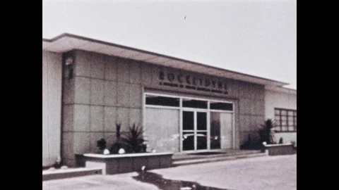1960s: Entrance to building. Rocket testing site. Model of astronaut standing Vídeos de archivo 101404106