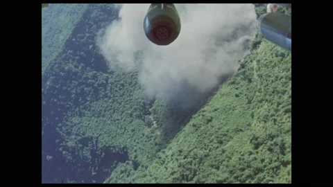 1960s: Explosion on land. Smoke hovers over land. Aerial view of mountains. Stock Footage 141344853