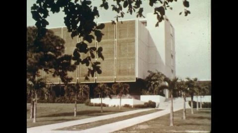 1960s: Exterior of corporate building / Zoom in on picture of model city / Stock Footage