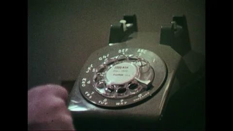 1960s: Finger dials number on phone. Man speaks on telephone. Stock Footage