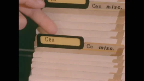 1960s: Fingers sort through tabbed folders and file paperwork in filing cabinet 스톡 동영상 222956268