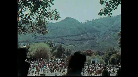 1960s footage of hippies at an outdoor msuic concert, doing drugs and dancing to Stock Footage