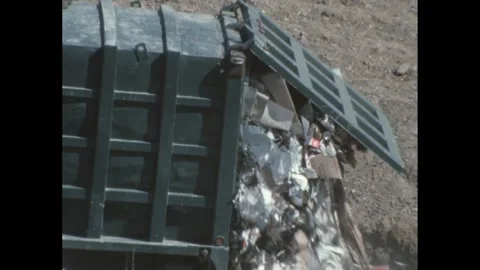 1960s: Garbage truck dumps garbage into landfill. Stock Footage 244535721