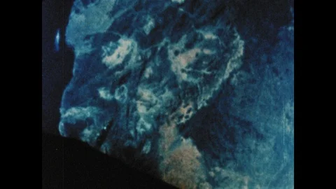 1960s: Gemini space craft floats above clouds and terrain in Earth's orbit. Stock Footage 101665497