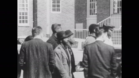 1960s: Group of people stand by side of road with police officers. Officers help Stock Footage 137409256