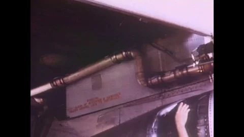 1960s: Hand points to pipes on underside of plane. Man points to engine, group Video stock 84806698