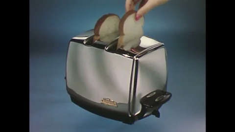 1960s: Hand puts bread in toaster / Interior of toaster, toast darkens / Toast Stock Footage