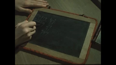 1960s: Hands doing math problem on chalkboard. Stock Footage 246751590