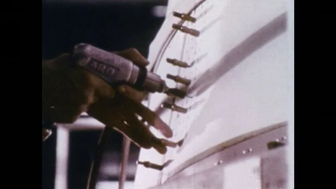 1960s: Hands screw in bolts / View of man / Hand pour molten metal / Hands with Stock Footage