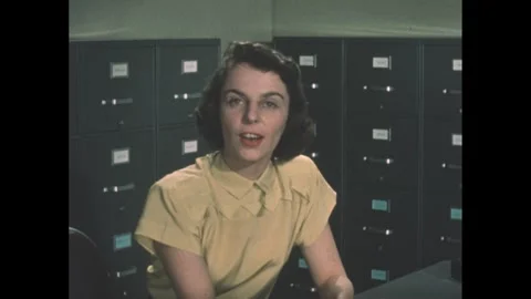 1960s: Hands sort through open filing cabinet drawer. Hands place folder in Stock Footage 240683550