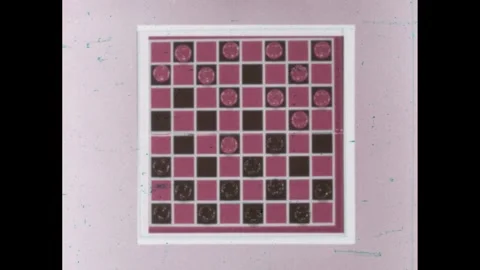 1960s: High angle of checkerboard, hand playing checkers, borders appear, zoom Stock Footage 262087379
