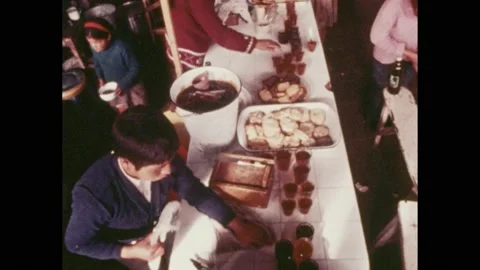1960s: High angle, people preparing food at table. Hands pick up tray of bread. 스톡 동영상 169234601