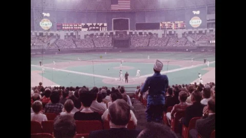 1960s: High angle view of baseball game, crowd in foreground. Pan across crowd Stock Footage