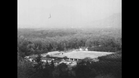 1960s: High angle view of factory. Man shoveling coffee beans. Men fill bag with Stock Footage 94096187
