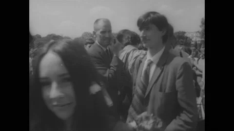 1960s: Hippie festival in Hyde Park, London. Protest posters. Man smoking pot. Stock Footage