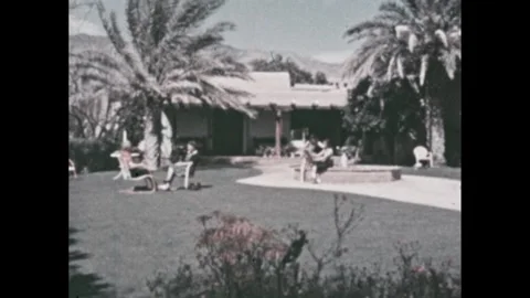 1960s: Hotel in Phoenix with palms and grass. Swimming pool in desert. Desert Vídeo Stock 286714930