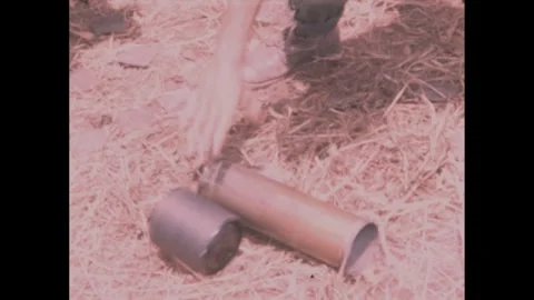 1960s: Howitzer ejects metal bullet shells. Soldier tosses shells as they hit 库存影片 270000024