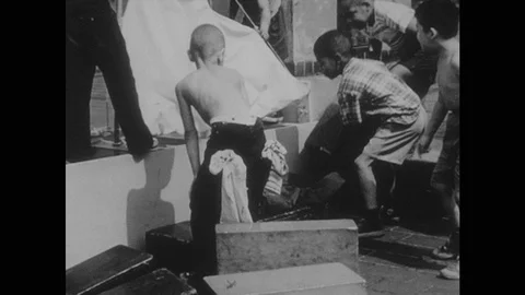 1960s: Kids stack blocks around toy boat. Kids playing, stacking blocks. Boy 動画素材 124338303