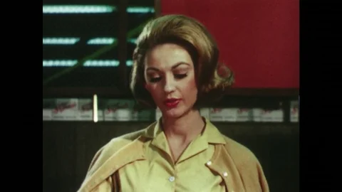 1960s: lady gives coupons to check out supervisor. Lady punches numbers into Stock Footage