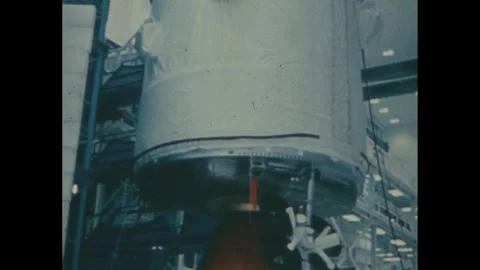1960s: Large rocket part being moved by crane in the assembly building. Vídeos de archivo 276428158