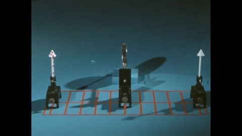 1960s: Lowered mirror between two objects, camera pans around behind an object. Stock Footage 247158547