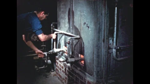 1960s: Man adjusts kiln knobs on kiln. Man presses against kiln door. Man 스톡 동영상 110800805