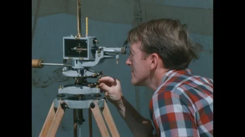 1960s: Man adjusts knobs of magnetometer under tent. 스톡 동영상 272975601