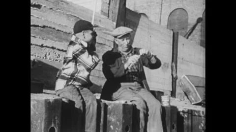 1960s: Man and boy fish from dock.  Boy pulls fish out of water.  Fishing boat.  Stock Footage 295371700