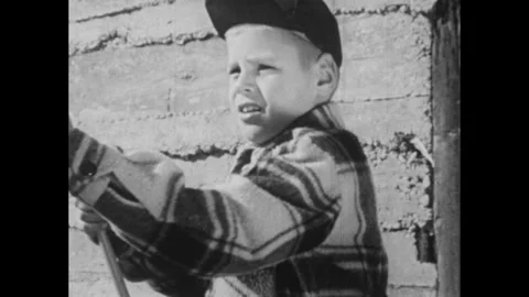 1960s: Man and boy sit on dock and fish.  Boy checks line and waves fishing Stock Footage 295371723