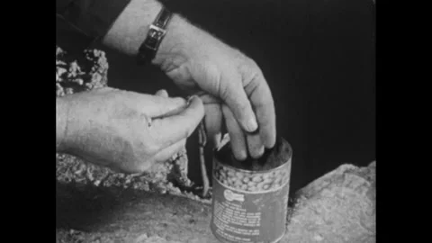 1960s: Man and boy sit on dock.  Man reaches into tin can and pulls out worms.  Stock Footage 295371731